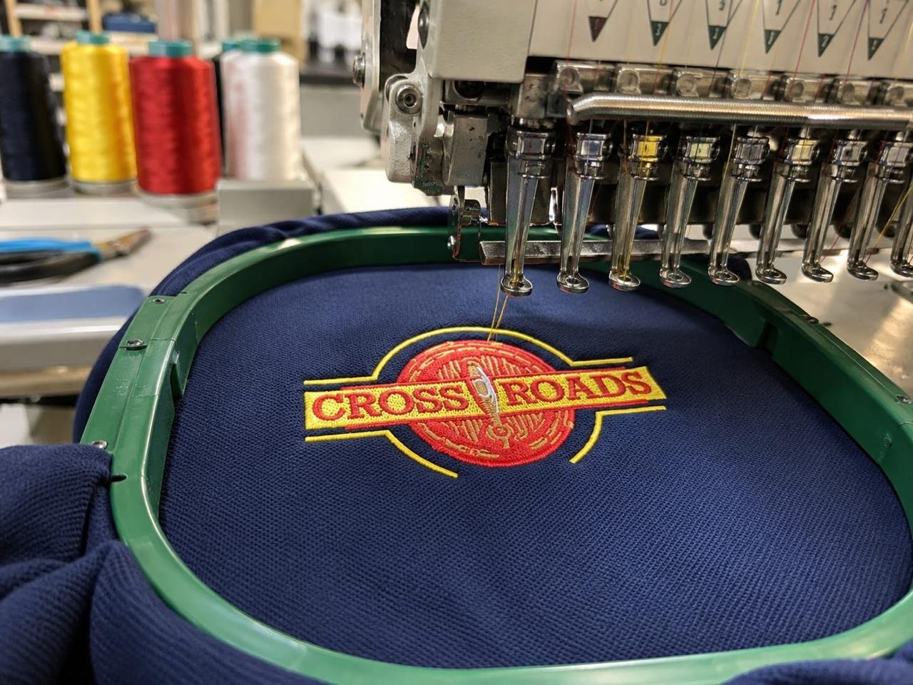 Front view of embroidery machine heads with finished branding